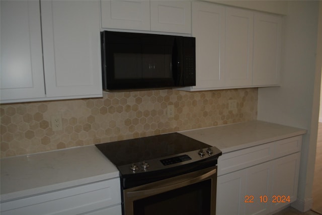 7575 Katy Fwy Unit 9, Houston, TX 77024 - kitchen with stainless steel electric range, black microwave, white cabinets, and light countertops