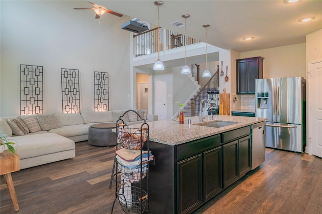 2515 Lilac Point Ln, Brookshire, TX 77423 - kitchen with stainless steel appliances, a sink, dark wood-type flooring, a ceiling fan, and tasteful backsplash