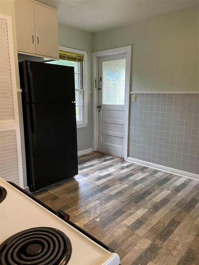 1116 Austin St, Rosenberg, TX 77471 - kitchen featuring freestanding refrigerator, wood finished floors, wainscoting, tile walls, and white electric range oven