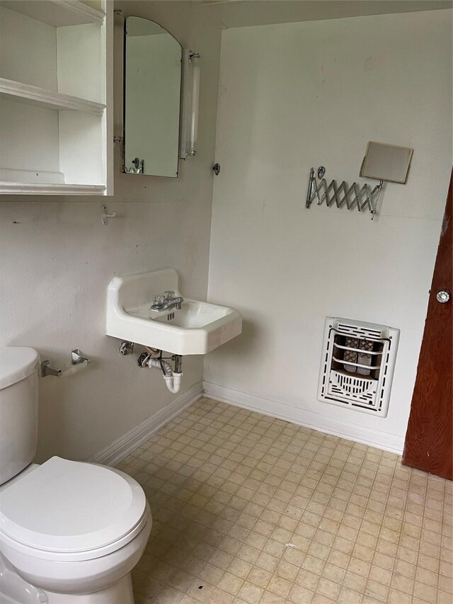 1116 Austin St, Rosenberg, TX 77471 - half bathroom with toilet, baseboards, tile patterned floors, a sink, and heating unit