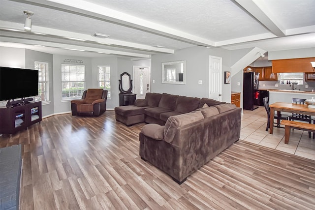 3638 Lost Oak Dr, Spring, TX 77388 - living room featuring beam ceiling, light wood finished floors, a textured ceiling, and baseboards