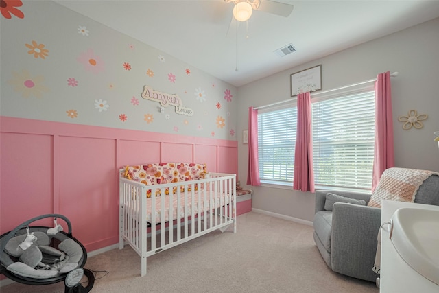 2446 Palisade Crest Dr, Rosharon, TX 77583 - bedroom featuring a crib, wainscoting, carpet, a ceiling fan, and a decorative wall