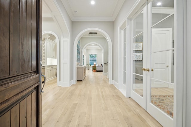 4654 Ingersoll St, Houston, TX 77027 - hallway featuring french doors, crown molding, arched walkways, light wood-style floors, and baseboards