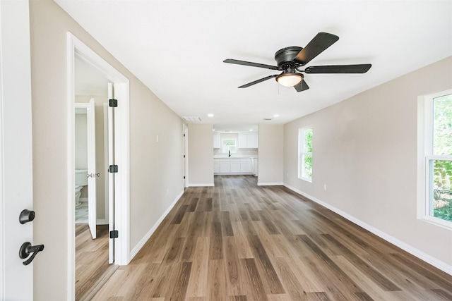 3108 Memel St, Houston, TX 77026 - spare room with wood finished floors, ceiling fan, baseboards, and healthy amount of natural light