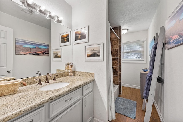 715 Timber Cove Dr, Seabrook, TX 77586 - full bathroom featuring vanity, a textured ceiling, wood finished floors, and shower / tub combo with curtain