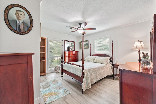 715 Timber Cove Dr, Seabrook, TX 77586 - bedroom featuring crown molding, multiple windows, light wood-style floors, a textured ceiling, and a ceiling fan