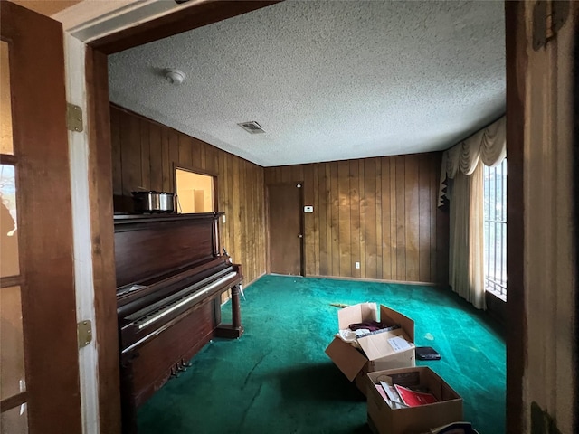 7261 Yoe St, Houston, TX 77016 - sitting room with carpet floors, wood walls, and a textured ceiling