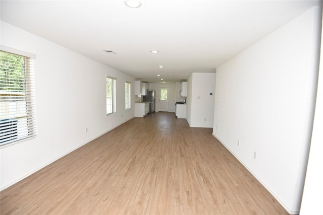19591 Manduca Dr, New Caney, TX 77357 - unfurnished living room featuring light wood finished floors and recessed lighting