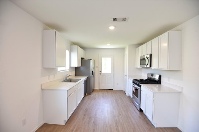 19591 Manduca Dr, New Caney, TX 77357 - kitchen featuring stainless steel appliances, a sink, light wood-style flooring, light countertops, and recessed lighting