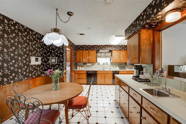 3819 Ridgeview Dr, Missouri City, TX 77459 - kitchen featuring wallpapered walls, a sink, a textured ceiling, dishwasher, and brown cabinets