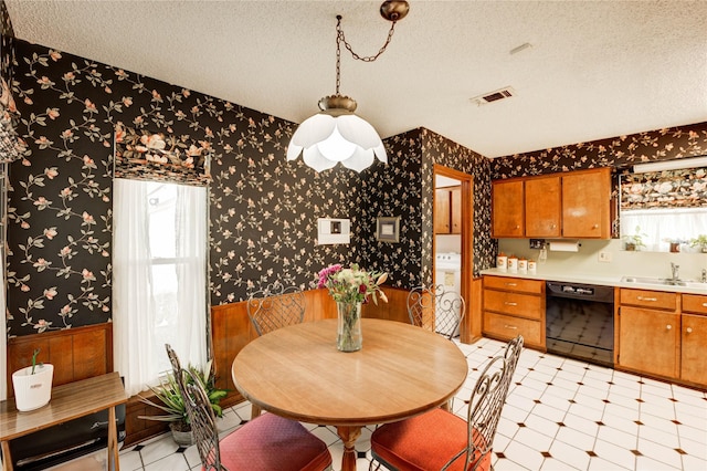 3819 Ridgeview Dr, Missouri City, TX 77459 - dining area featuring wallpapered walls, a wainscoted wall, a textured ceiling, washer / dryer, and light flooring