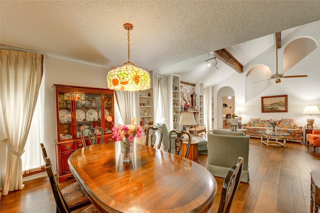 3819 Ridgeview Dr, Missouri City, TX 77459 - dining area featuring vaulted ceiling, arched walkways, a ceiling fan, a textured ceiling, and dark wood-style floors