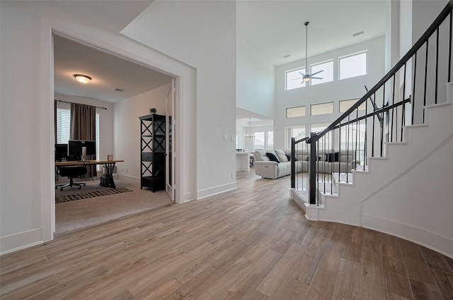 23604 Olive Creek Ln, New Caney, TX 77357 - entryway featuring a ceiling fan, light wood finished floors, stairs, baseboards, and a towering ceiling