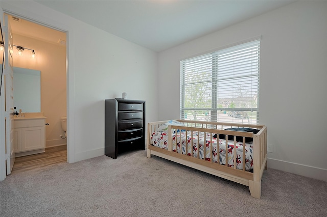 23604 Olive Creek Ln, New Caney, TX 77357 - bedroom with light carpet, baseboards, and connected bathroom