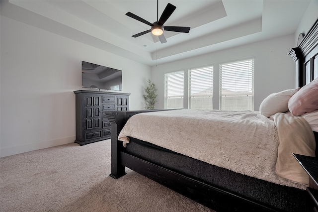 23604 Olive Creek Ln, New Caney, TX 77357 - bedroom featuring a tray ceiling, carpet floors, baseboards, and a ceiling fan