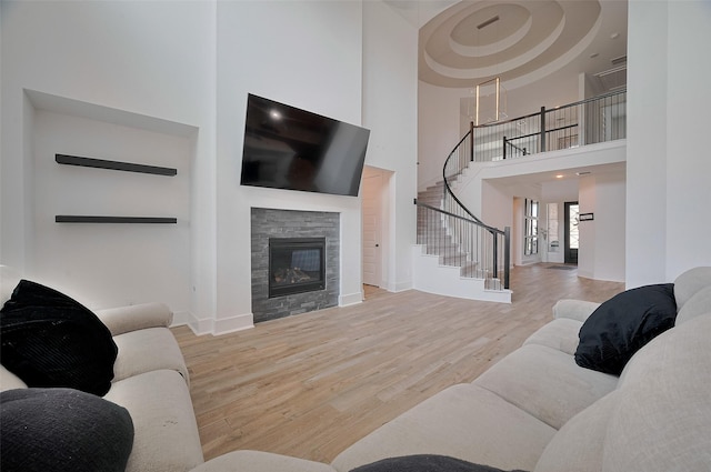 23604 Olive Creek Ln, New Caney, TX 77357 - living room with a towering ceiling, stairs, wood finished floors, baseboards, and a stone fireplace