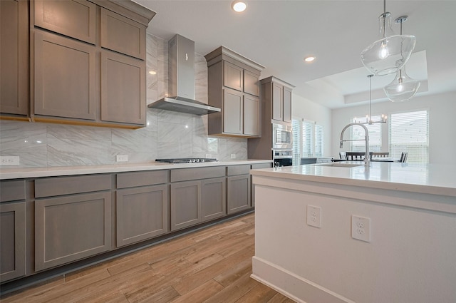 23604 Olive Creek Ln, New Caney, TX 77357 - kitchen featuring wall chimney exhaust hood, gray cabinetry, a sink, and recessed lighting