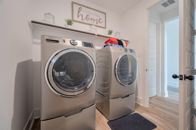 23604 Olive Creek Ln, New Caney, TX 77357 - laundry room with light wood-type flooring, independent washer and dryer, and baseboards