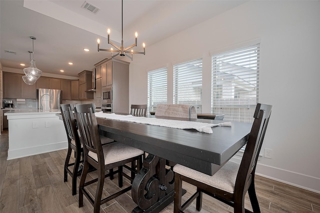 23604 Olive Creek Ln, New Caney, TX 77357 - dining space featuring wood finished floors, a chandelier, recessed lighting, and baseboards