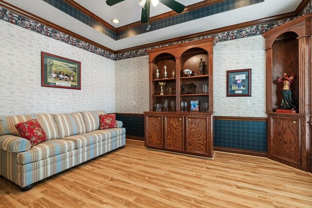 60 Fairfield Dr, Montgomery, TX 77356 - living room with wallpapered walls, wainscoting, crown molding, light wood-type flooring, and a ceiling fan