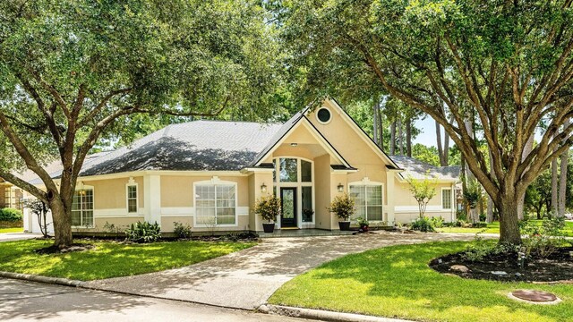 60 Fairfield Dr, Montgomery, TX 77356 - view of front of property featuring stucco siding, concrete driveway, and a front lawn