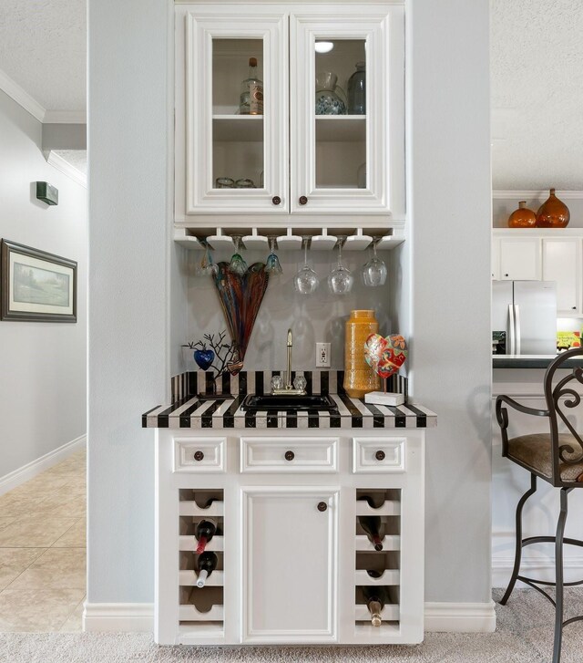 60 Fairfield Dr, Montgomery, TX 77356 - indoor dry bar with stainless steel refrigerator with ice dispenser, crown molding, baseboards, and a textured ceiling