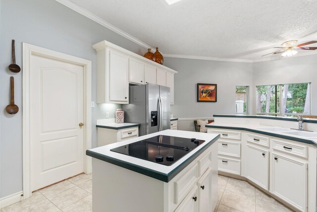 60 Fairfield Dr, Montgomery, TX 77356 - kitchen featuring stainless steel fridge, black electric stovetop, a sink, light tile patterned floors, and a textured ceiling