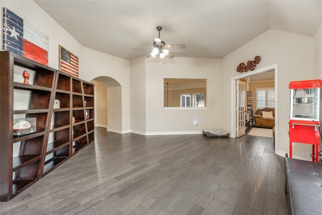 3221 Duchess Park Ln, Friendswood, TX 77546 - unfurnished living room with arched walkways, a ceiling fan, dark wood finished floors, baseboards, and vaulted ceiling