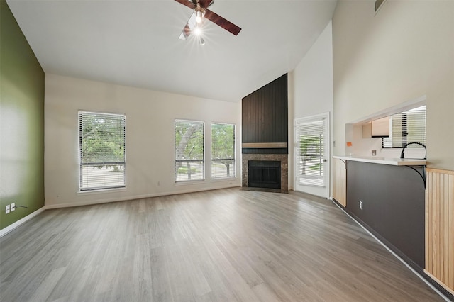 4144 Greystone Way Unit 305, Sugar Land, TX 77479 - unfurnished living room featuring high vaulted ceiling, a ceiling fan, light wood-type flooring, a fireplace, and baseboards