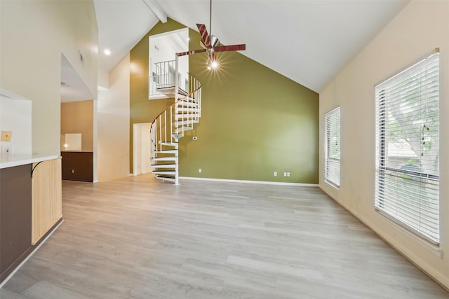 4144 Greystone Way Unit 305, Sugar Land, TX 77479 - unfurnished living room with stairway, high vaulted ceiling, beamed ceiling, light wood-type flooring, and baseboards