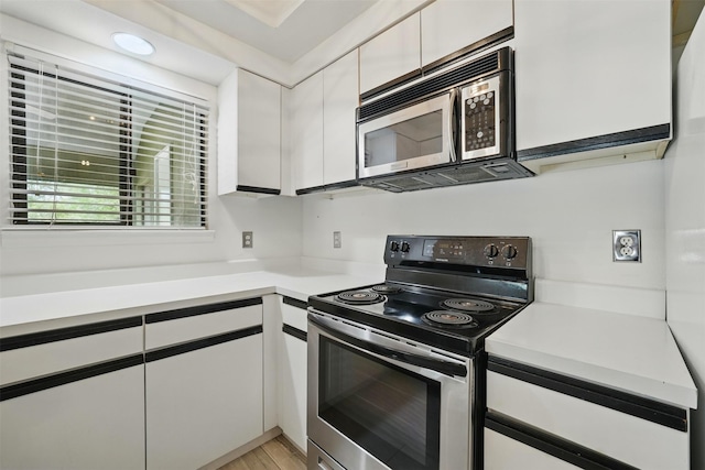 4144 Greystone Way Unit 305, Sugar Land, TX 77479 - kitchen with appliances with stainless steel finishes, light countertops, white cabinets, and light wood-style floors