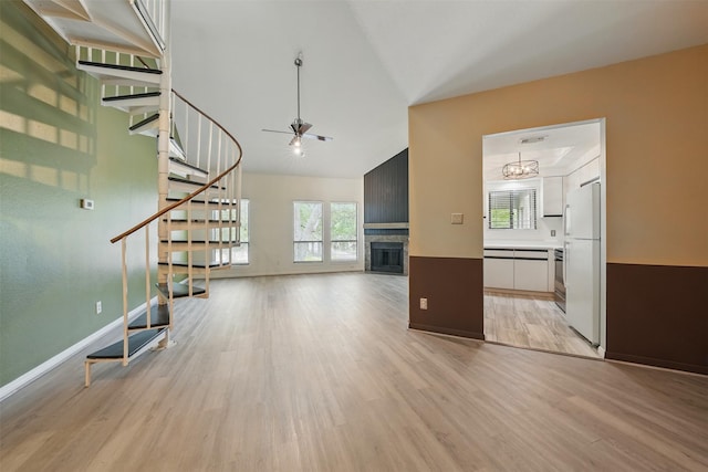 4144 Greystone Way Unit 305, Sugar Land, TX 77479 - unfurnished living room featuring stairway, light wood-type flooring, healthy amount of natural light, and lofted ceiling