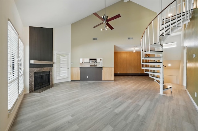 4144 Greystone Way Unit 305, Sugar Land, TX 77479 - unfurnished living room with high vaulted ceiling, a ceiling fan, stairs, light wood finished floors, and a fireplace