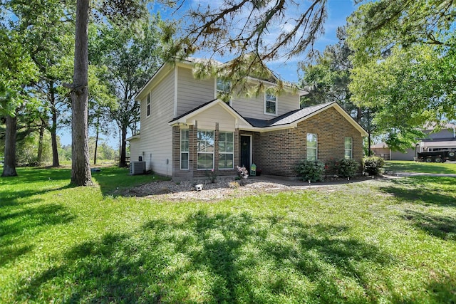 25401 Hunting Trl, Magnolia, TX 77355 - view of front of house with central AC unit, brick siding, and a front lawn