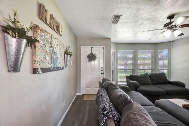 25401 Hunting Trl, Magnolia, TX 77355 - living room featuring ceiling fan, baseboards, dark wood-style floors, and a textured ceiling