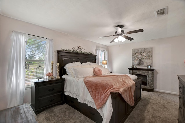 25401 Hunting Trl, Magnolia, TX 77355 - bedroom with carpet flooring, a stone fireplace, a ceiling fan, and baseboards
