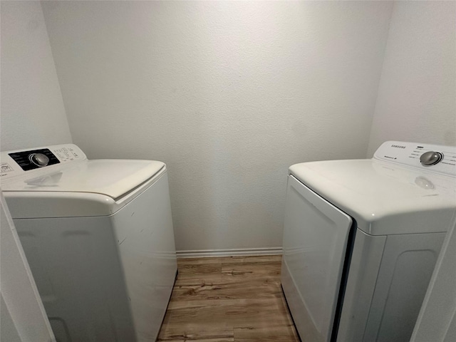 11079 N Lake Mist Ln, Willis, TX 77318 - laundry area with washing machine and dryer, wood finished floors, and baseboards
