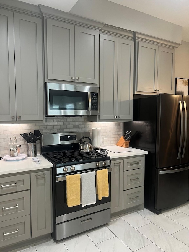 5339 Canyon Hollow Dr, Houston, TX 77084 - kitchen featuring stainless steel appliances, gray cabinets, light countertops, and backsplash