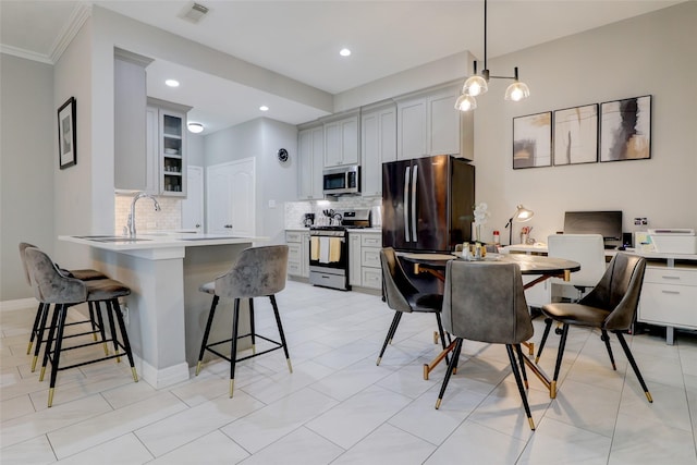 5339 Canyon Hollow Dr, Houston, TX 77084 - kitchen with appliances with stainless steel finishes, a peninsula, a breakfast bar area, backsplash, and glass insert cabinets