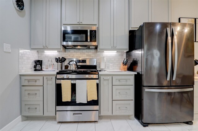 5339 Canyon Hollow Dr, Houston, TX 77084 - kitchen featuring appliances with stainless steel finishes, light countertops, tasteful backsplash, and baseboards