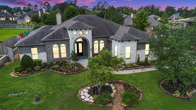 40610 Ithaca Ln, Magnolia, TX 77354 - french country home with a chimney, stone siding, roof with shingles, and brick siding