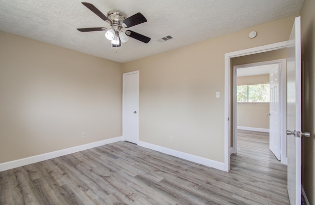 18011 Glenledi Dr, Houston, TX 77084 - unfurnished room with light wood finished floors, ceiling fan, a textured ceiling, baseboards, and a smoke detector