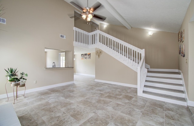 18011 Glenledi Dr, Houston, TX 77084 - unfurnished living room with ceiling fan, stairs, baseboards, beam ceiling, and high vaulted ceiling
