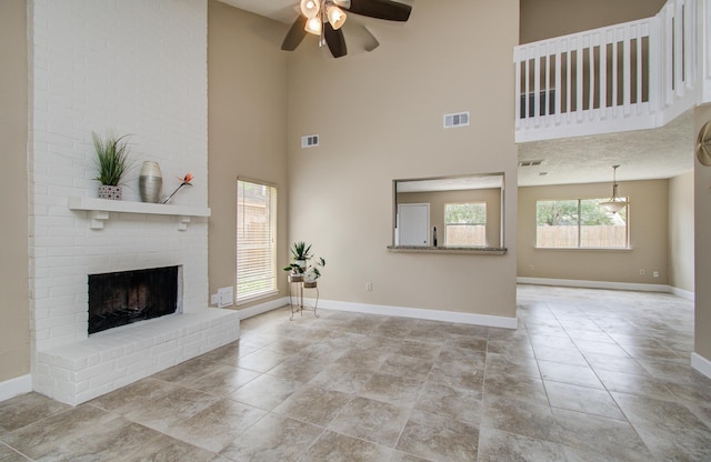 18011 Glenledi Dr, Houston, TX 77084 - unfurnished living room featuring ceiling fan, baseboards, a brick fireplace, and a high ceiling