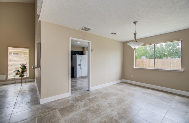 18011 Glenledi Dr, Houston, TX 77084 - unfurnished room featuring baseboards, a textured ceiling, and light tile patterned floors