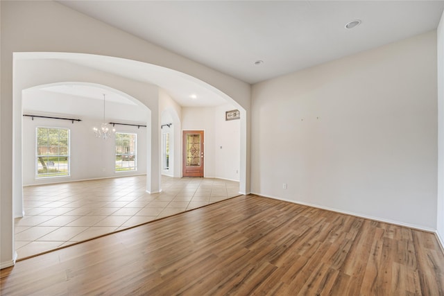 31827 Oak Thicket Ct, Conroe, TX 77385 - empty room featuring wood finished floors, a chandelier, arched walkways, and recessed lighting