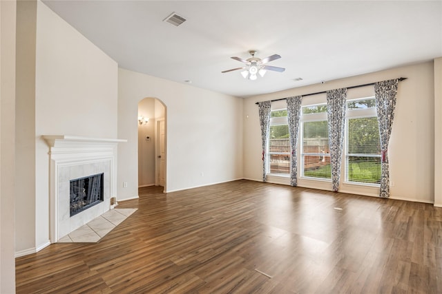 31827 Oak Thicket Ct, Conroe, TX 77385 - unfurnished living room with arched walkways, a ceiling fan, wood finished floors, and a fireplace