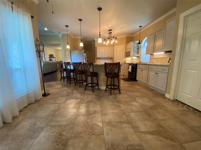216 Dewberry Dr, Lake Jackson, TX 77566 - kitchen featuring ornamental molding, light stone countertops, a breakfast bar, backsplash, and white cabinetry