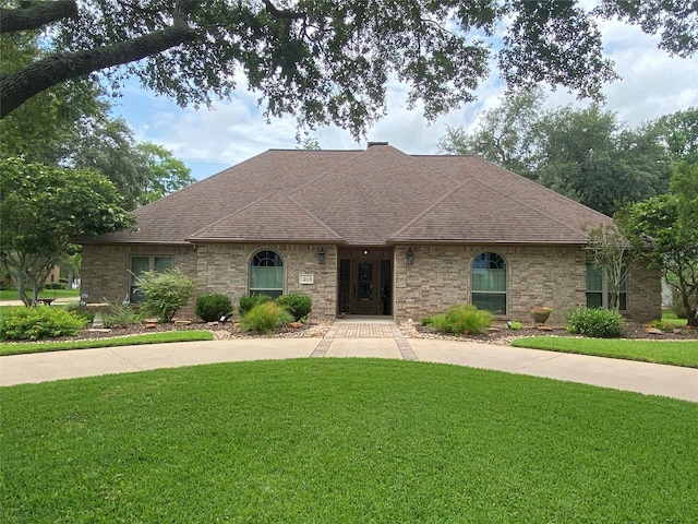 216 Dewberry Dr, Lake Jackson, TX 77566 - french country home with a front yard and a shingled roof