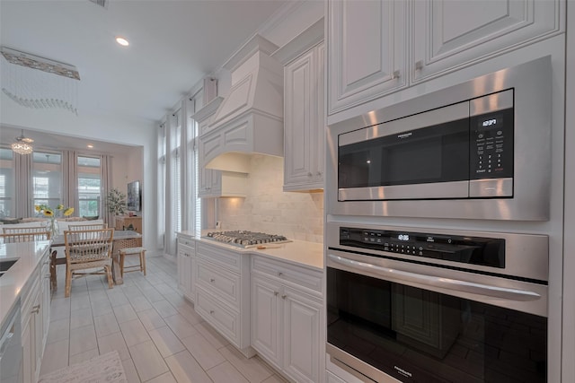 10615 Winding Arbor Ct, Cypress, TX 77433 - kitchen with stainless steel appliances, backsplash, white cabinetry, light countertops, and recessed lighting